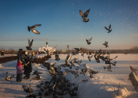 Murom, Russia - January 07, 2019: Orthodox priest feeding pigeons in the Spaso-Preobrazhensky monastery in Murom, Russiaのeditorial素材