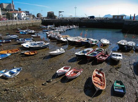 Image of multi-colored boats in the port of Castro Urdiales at low tide, Spain