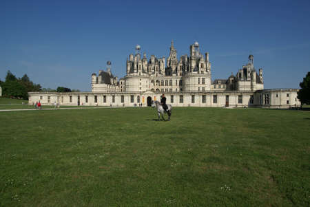 Chambord, Castles of the Loire, France - May 11, 2008, Man on a horse on the lawn near the castle of Chambord, Castles of the Loire, Franceのeditorial素材