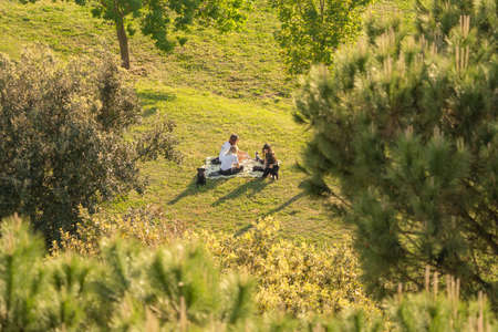 Rome, Italy - May 05, 2020, Three girls and two dogs at  picnic on a meadow in Italyのeditorial素材