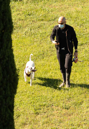 Rome, Italy - May 21, 2020, People in medical masks walking dogs in a Rome park, Italy during self-isolationのeditorial素材