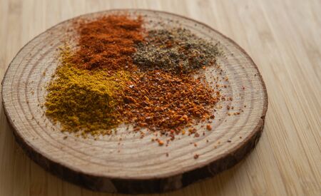 Image of variety of peppers, paprika and curry on a wooden standの写真素材