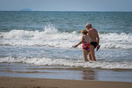 Bufalara, Italy - Septembre 02, 2020, Man and woman going along the beach. Second wave of coronavirus in Italy (covid19)のeditorial素材