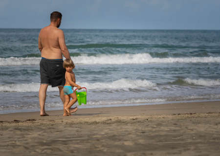 Bufalara, Italy - Septembre 02, 2020, Father and son going along the beach. Second wave of coronavirus in Italy (covid19)のeditorial素材