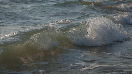 Colored sea waves with splashes and white breakers in Circeo park in Sabaudia in Italy