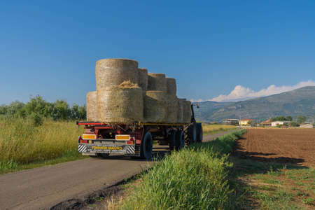Latina, Italy - June 13, 2021, Tractor transporting sheaves in fields in province of Latina, Fronzinone, Italyのeditorial素材