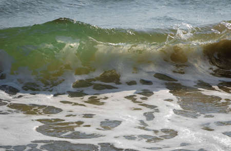 Colored sea waves with splashes and white breakers in Circeo park in Sabaudia in Italy