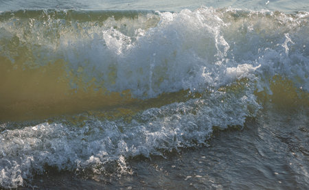 Close up view of colored sea waves with splashes and white breakers in Circeo park in Sabaudia in...