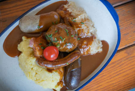Image of assorted sausages and cutlets, mashed potatoes, stewed cabbage, traditional, German dishの写真素材