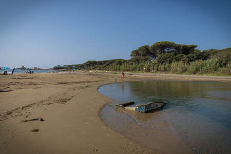 Torre Astura, Italy - September 12, 2021, Woman and her reflection in the river flowing into the sea at Torre Astura in Italyのeditorial素材
