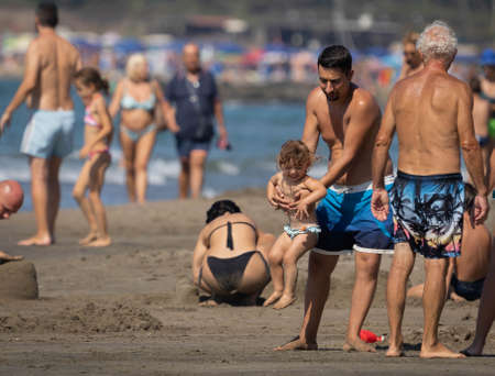 Marina di San Nikola, Italy - September 05, 2021, Father playing with his daughter on the beach of Marina San Nicola in Italyのeditorial素材