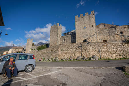 Vico nel Lazio, Italy - December 12, 2021, Old man resting on chair near castle walls of Borgo Vico nel Lazio in province of Fronzinone in Italyのeditorial素材