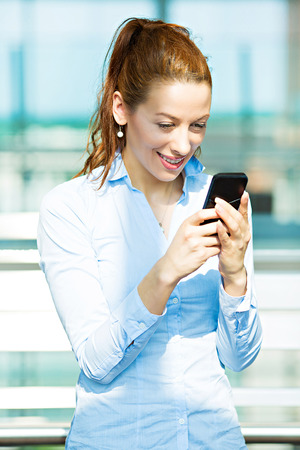 Closeup portrait business woman texting on mobile phone  Businesswoman sending message on cellphone while walking  の写真素材