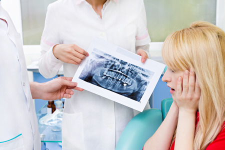 Closeup portrait worried scared female patient, woman siting in chair medical officeの写真素材