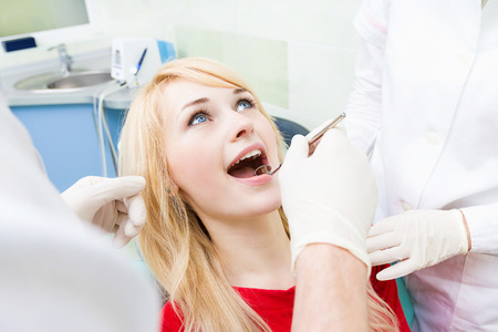 Closeup portrait young female, woman, patient sitting in dentist chairの写真素材