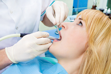 Closeup portrait young female, woman, patient sitting in dentist chairの写真素材