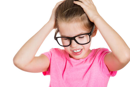 Closeup portrait stressed out, sad little girl, overwhelmed, having headache, hands on head, worried, isolated white background. Human face expressions, emotions, feelings, reaction, life perceptionの写真素材