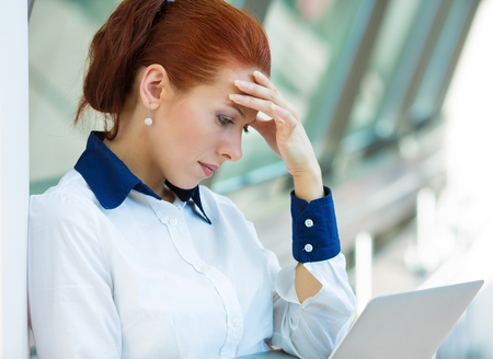 Closeup portrait unhappy business woman, hand on head standingの写真素材