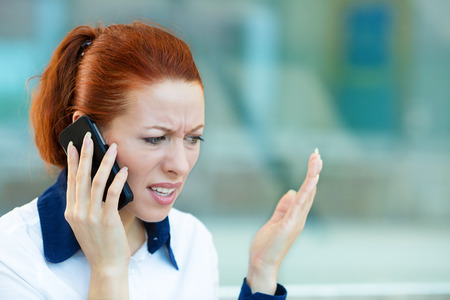 Closeup portrait upset sad, skeptical, unhappy, serious woman talking on phoneの写真素材