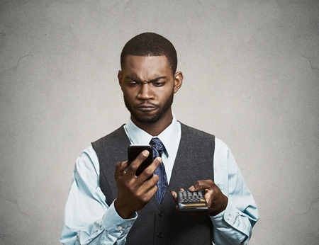 Closeup portrait handsome, serious looking worried businessman reading bad news on smart phone holding mobileの写真素材