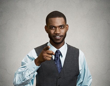 Closeup portrait, headshot young smiling handsome man pointing at you with index finger, isolated black grey background. Positive human emotion facial expression feeling, sign, symbols, body languageの写真素材