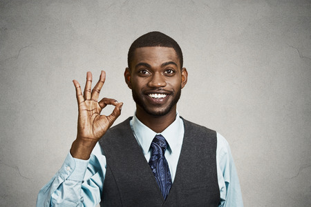Closeup portrait young handsome, happy, smiling, excited man, corporate employee, worker giving OK sign with fingers, isolated black grey background. Positive human emotion facial expressions, symbolの写真素材