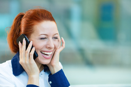 Closeup portrait, smiling attractive successful businesswoman, entrepreneur, corporate employee talking on cellphone, walking in company building, isolated background office windows. Positive emotionの写真素材