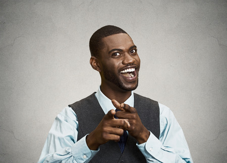 Closeup portrait, young handsome business man with two hands guns sign gesture pointing at you camera, isolated black grey background. Positive human emotion facial expression feelings, signs, symbolsの写真素材