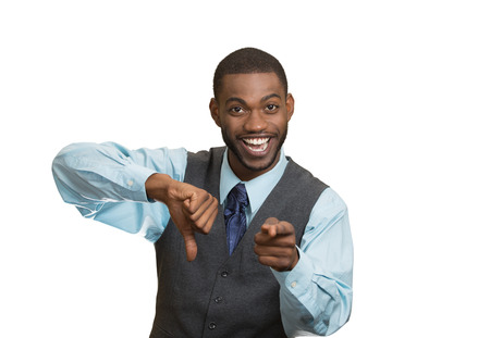 Closeup portrait sarcastic young man showing one thumbs down sign hand gesture, happy that someone made mistake, lost, failed isolated white background. Negative emotions, facial expressions, feelingsの写真素材