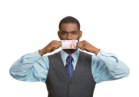 Closeup portrait handsome young corrupt corporate man in blue shirt holding euro bill currency to his mouth, isolated white background. Bribery concept in politics business, diplomacy. Life perceptionの写真素材