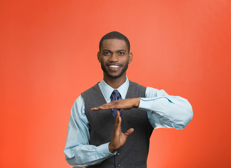 Closeup portrait young, happy, smiling, executive company man showing time out gesture with hands, isolated red background. Positive human emotion, facial expression feelings, body language, attitudeの写真素材