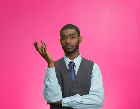 Closeup portrait dumb clueless young executive man, arm out asking why what problem so who cares, I don't know, isolated pink color background. Negative human emotion facial expression feelingsの写真素材