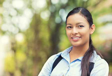 Closeup headshot portrait, happy, young beautiful business woman in blue shirt smiling isolated outdoors background with trees  Positive human emotions, facial expressionsの写真素材
