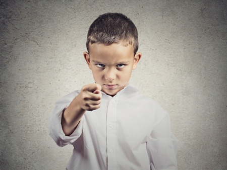 Closeup portrait serious, unhappy child, boy with Hand in Figa mudra isolated grey wall background. Negative human emotions, feelings, facial expressions, body language, life perception, attitudeの写真素材