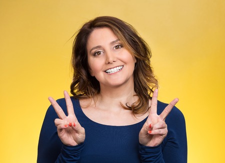 Closeup portrait, young, middle aged smiling woman, giving peace, victory, two sign, with hands...