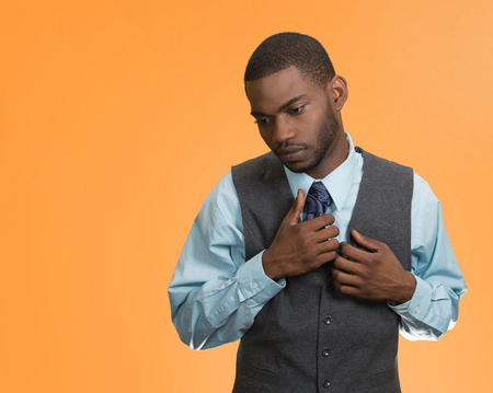 Awkward situation, shy, sad young handsome business man, isolated orange background. human emotions, feelings, face expressions, body language,life perception, workplace subordination, lack of opinionの写真素材