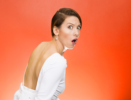 Paranoia. Portrait young scared afraid woman citizen, employee, full of fear on a run, chased by someone isolated red background. Human face expressions, emotions, reaction, feelings, attitudeの写真素材