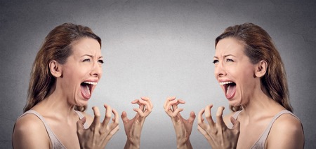 Closeup portrait angry woman hysterical having nervous breakdown screaming pissed off  at herself in mirror isolated grey wall background. Negative human emotion facial expression feeling bad attitudeの写真素材