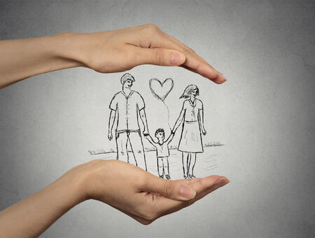 close up of woman's hands protecting happy family, mother, father, child. Family abstract in palms on grey wall background. Safe childhood, parenting. Love care compassion safety secure future conceptの写真素材