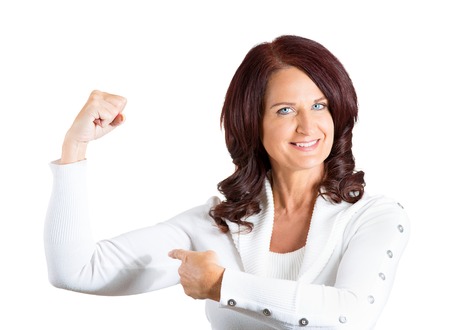 Closeup portrait middle aged woman flexing muscles showing, displaying her strength, isolated white background. Positive human emotions, facial expressions, feelings, attitude, life perceptionの写真素材