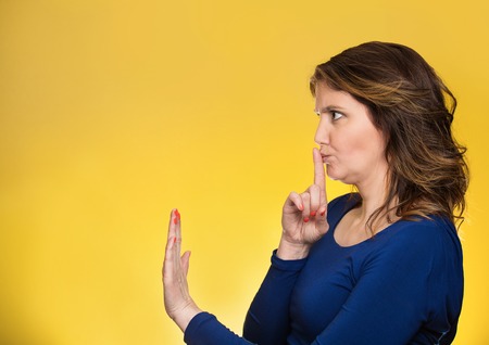 Closeup side view profile portrait serious woman finger, hand on lips, shhh gesture asking be quiet...