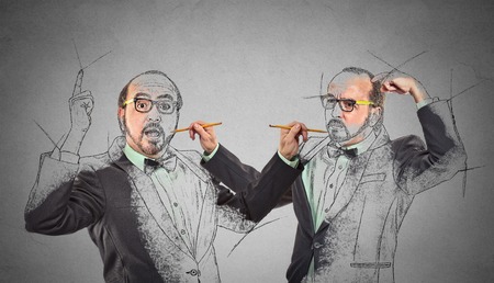 Create yourself, your future destiny, image, career concept. Middle aged man drawing a picture, sketch of himself on grey wall background. Human face expressions, determination, creativity imaginationの写真素材