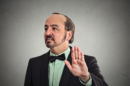 Closeup portrait middle aged handsome grumpy man with bad attitude giving talk to hand gesture with...