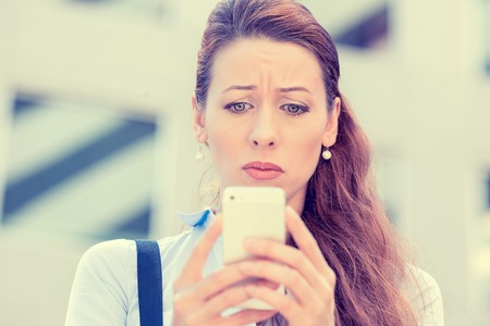 Upset stressed woman holding cellphone disgusted with message she received isolated corporate...