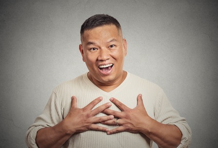 Closeup portrait happy middle aged handsome man looking shocked surprised in disbelief hands on chest open mouth eyes isolated grey wall background. Positive human emotion facial expression feelingの写真素材