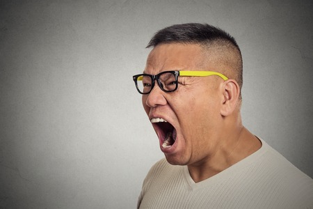 Side profile portrait bitter mad displeased pissed off angry grumpy middle aged man with glasses open mouth screaming yelling isolated grey background. Negative human emotion facial expression feelingの写真素材