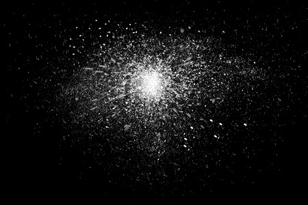 Freeze motion of white powder exploding, isolated on black, dark background. Abstract design of white dust cloud. Particles explosion screen saver, wallpaper with copy space. Planet creation conceptの写真素材
