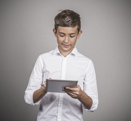 Modern communication technology mobile pad computer high tech, wide web connection concept. Teenager boy holding portable pc isolated on gray wall background. Data plan providerの写真素材