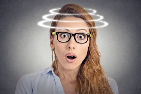 Head is spinning. Surprise astonished woman. Closeup portrait woman looking surprised in full disbelief wide open mouth isolated grey wall background. Human emotion face expression body language.の写真素材