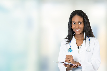 Portrait confident African American female doctor medical professional writing patient notes isolated on hospital clinic hallway windows background. Positive face expressionの素材 [FY31037957917]